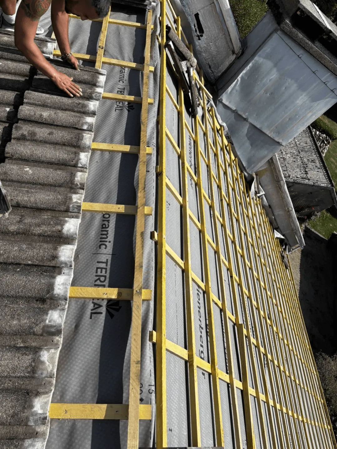 Écran de sous-toiture et liteaux entre deux rangées de tuiles, pendant des travaux